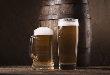 Beer barrel with beer glass on table on wooden background