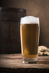Beer barrel with beer glass on table on wooden background
