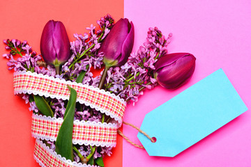 Tulip and lilac flowers with ribbon and blue note label