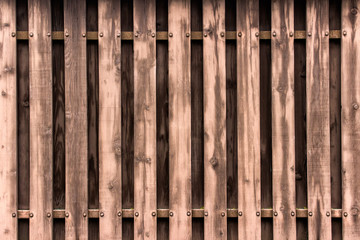 Texture of a wooden fence made with planks in brown colors.