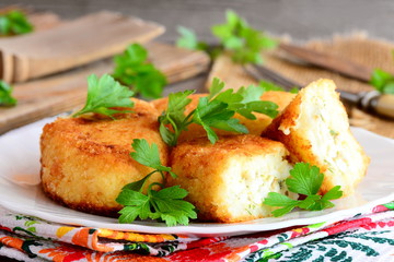 Vegetable cakes with eggs on a white plate. Homemade cauliflower and potatoes cakes stuffed with boiled sliced eggs. Rustic style. Closeup