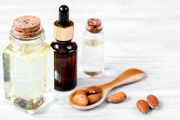 cosmetic almond oil in glass bottle on wooden background