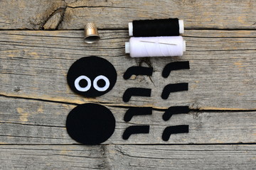 Making a Halloween felt  spider decoration. Step. Cut black and white felt details to create...