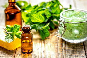 organic cosmetics with herbal extracts of mint on wooden backgro