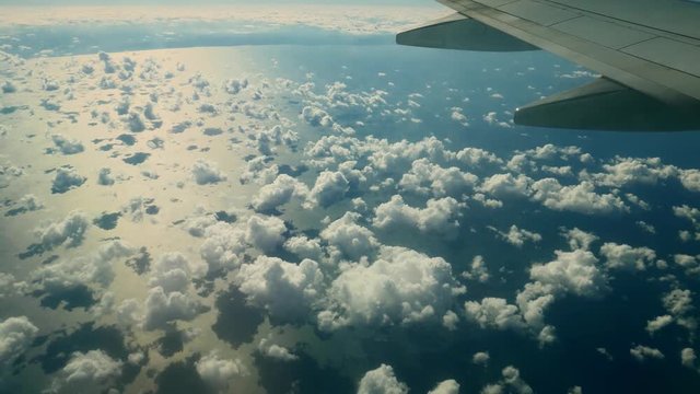 Aircraft plane, wing over cumulus clouds over the sea. Aerial survey 