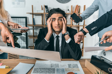 overworked businessman missing deadline due to work while colleagues pressing near by