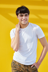 Happy man standing with one hand in pocket and other on shoulder