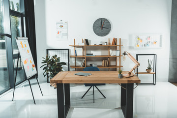 empty workplace with digital tablet on wooden table in modern office