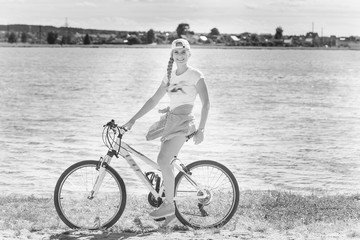 Fototapeta premium Girl on a bicycle by the lake