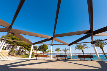 A small wooden pavilion with benches on the waterfront in L'Hospitalet de l'Infant, Tarragona, Catalunya, Spain. Copy space