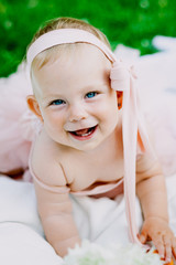 infancy and age concept . beautiful happy baby in pink dress in the park playing