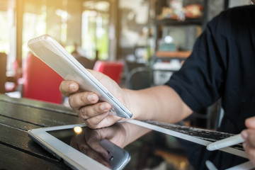 Businesswoman holds a white smartphone or smart device on her right hand and a stylus pen on the left hand, chats with friends via an instant messaging app over the public internet. Internet concept.