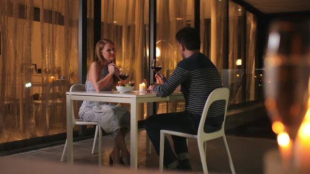 Young couple on the first date in the restaurant. The girl talks too much, the man suffers