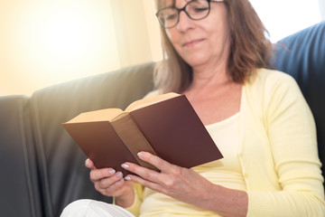 Mature woman reading a book, light effect