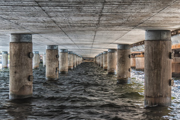Fototapeta na wymiar View under bridge with wooden columns