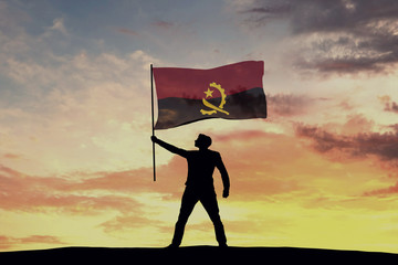 Male silhouette figure waving Angola flag. 3D Rendering