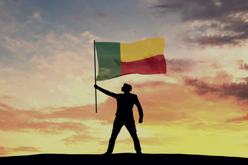 Male silhouette figure waving Benin flag. 3D Rendering