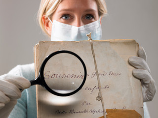 Woman with magnifying glass showing file
