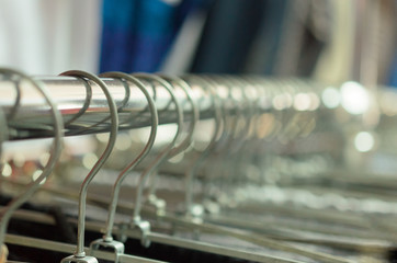 Many hangers in a row for clothes in the store.