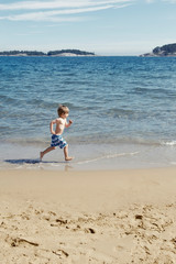 Boy running in waves on beach