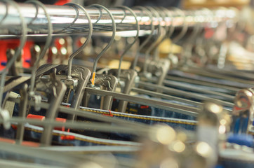 Many hangers in a row for clothes in the store.