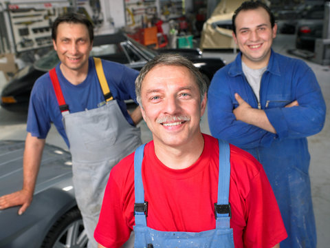 Three workers in a garage portrait.