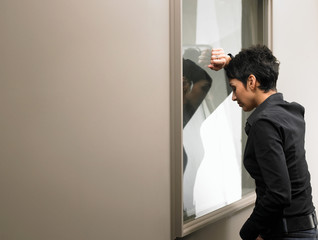 Businesswoman leaning against window