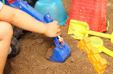 Close up of a child's hand playing sand toys.