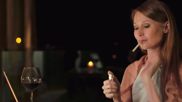The journalist smokes and writes a new article on the terrace of restaurant