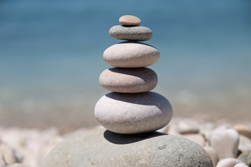 Fototapeta na wymiar stack of pebbles balance harmony zen - ocean or sea shore, refreshing blue waves summer, beach