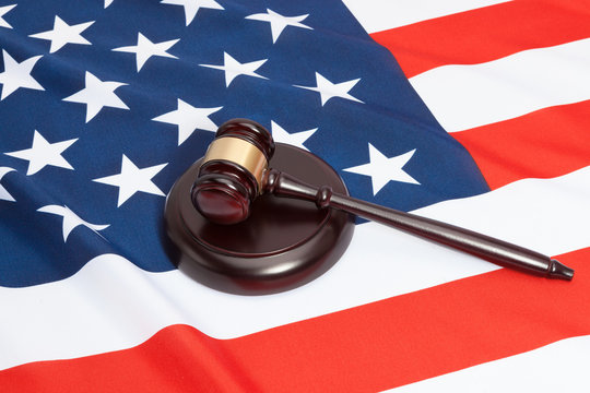 Close up studio shot of a judge gavel and soundboard laying over USA flag