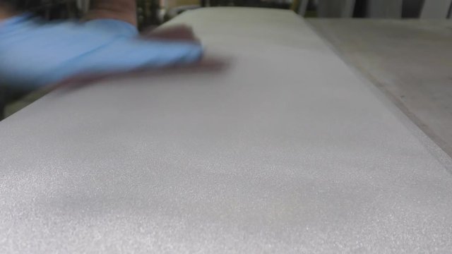 Man preparing metal panel with an abrasive pad