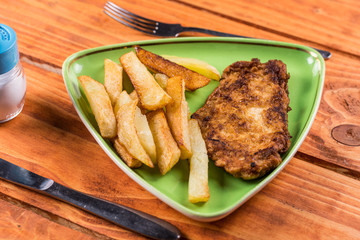Served meal on the plate with french fries and fried chicken breasts