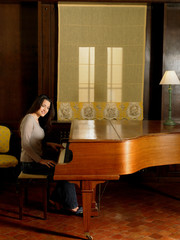Young woman playing piano smiling