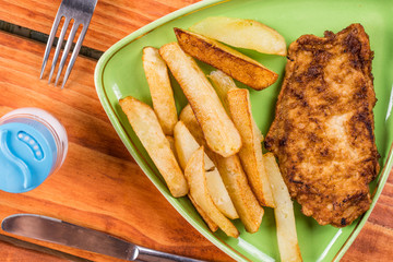 Served meal on the plate with french fries and fried chicken breasts