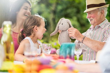 Three generations family picnic, grandfather plays with a kid