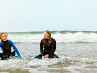 Female surfers sitting on surfboards