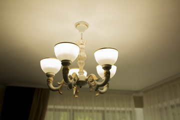 Modern chandelier on a white ceiling in a room
