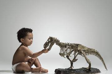 Toddler touching a dinosaur skeleton