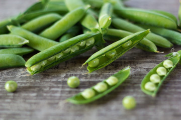 young juicy green peas on a wooden table