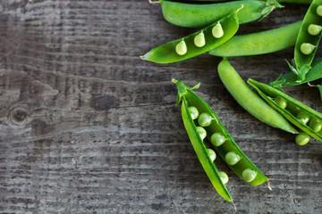 young juicy green peas on a wooden table. copy space