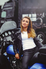 Obraz na płótnie Canvas Casual beautiful woman sits on a big tourist motorcycle on the street bright smile on a sunny day