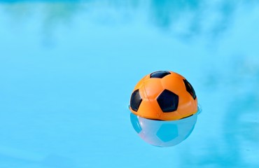 Fototapeta na wymiar Children playing ball floating in swimming pool.