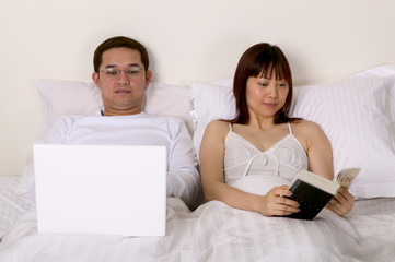 Couple in bed reading