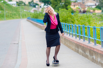 Senior business woman having fun on a skateboard outdoors. The concept of moving forward.