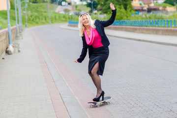 Senior business woman having fun on a skateboard outdoors. The concept of moving forward.