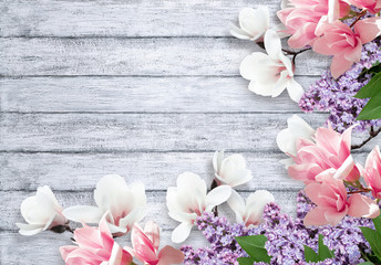 Magnolia and lilac flowers on shabby background