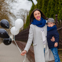 Portrait of fashionable baby boy and his gorgeous mother. little boy hugs his mother emotionally.
