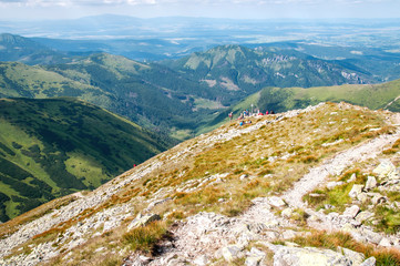 Fototapeta na wymiar Turyści przy skrzyżowaniu szlaków na tle gór.