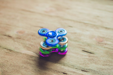 Colored fidget spinners stress relieving toy on wooden background